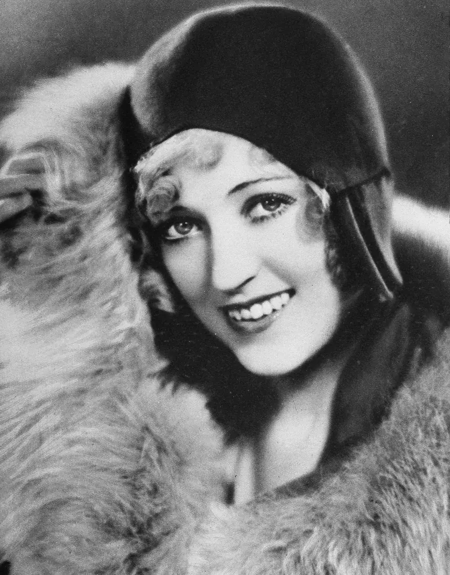 Studio portrait of Marion Davies in a dark cloche hat and fur wrap, 1930